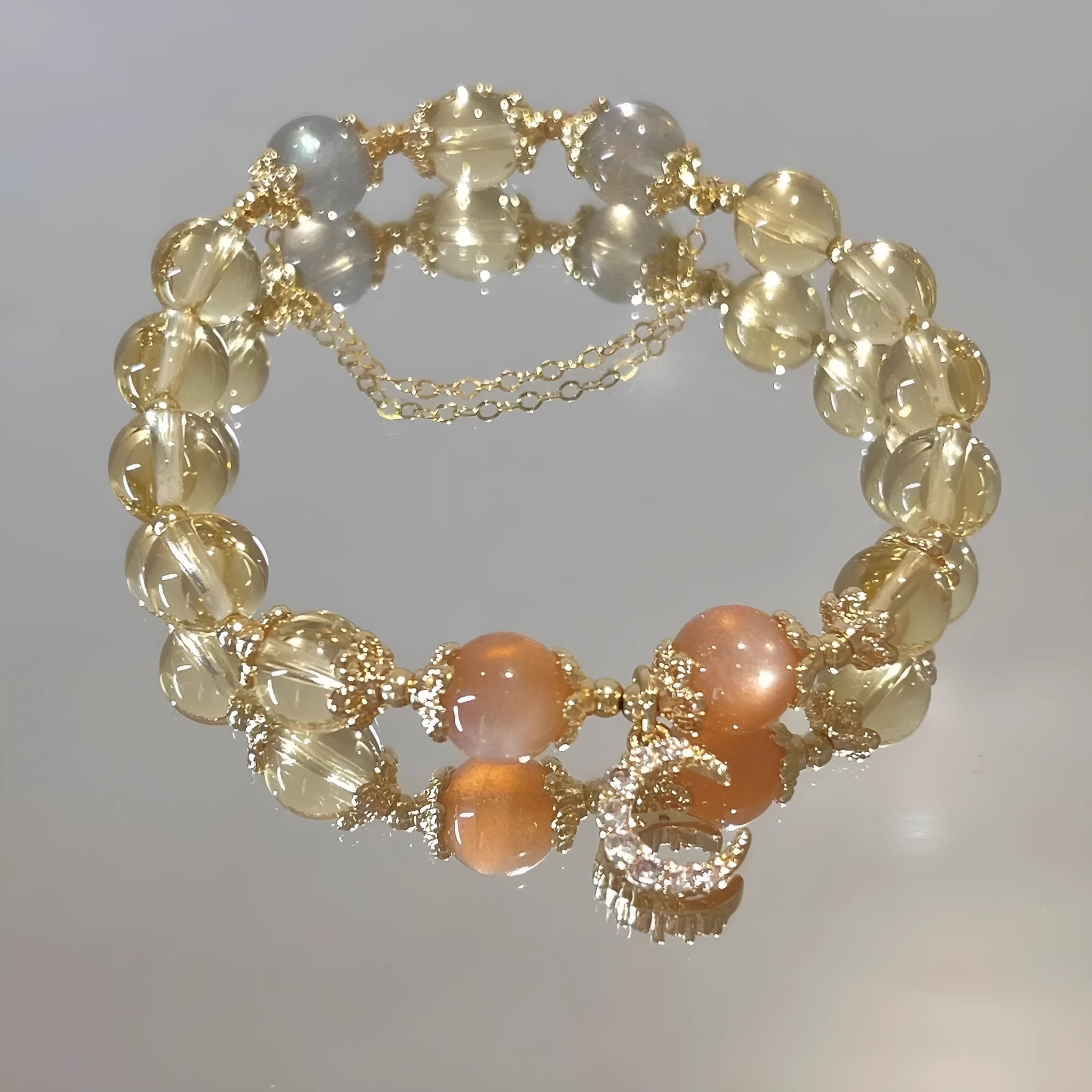 Women's crystal bracelet with moonstone and golden sun stone centrepiece, 14K gilded electroplated links, Chinese diamond-shaped style.