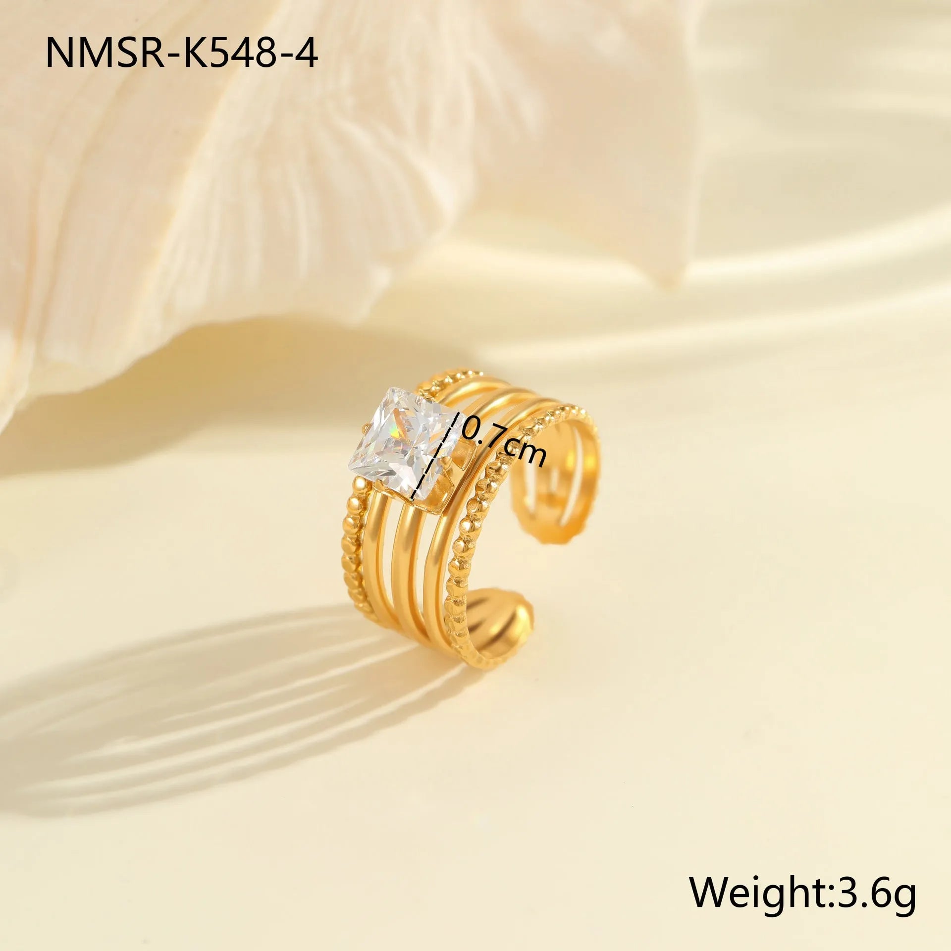 Gold-coloured adjustable stainless steel ring with zircon geometric shapes on white background.