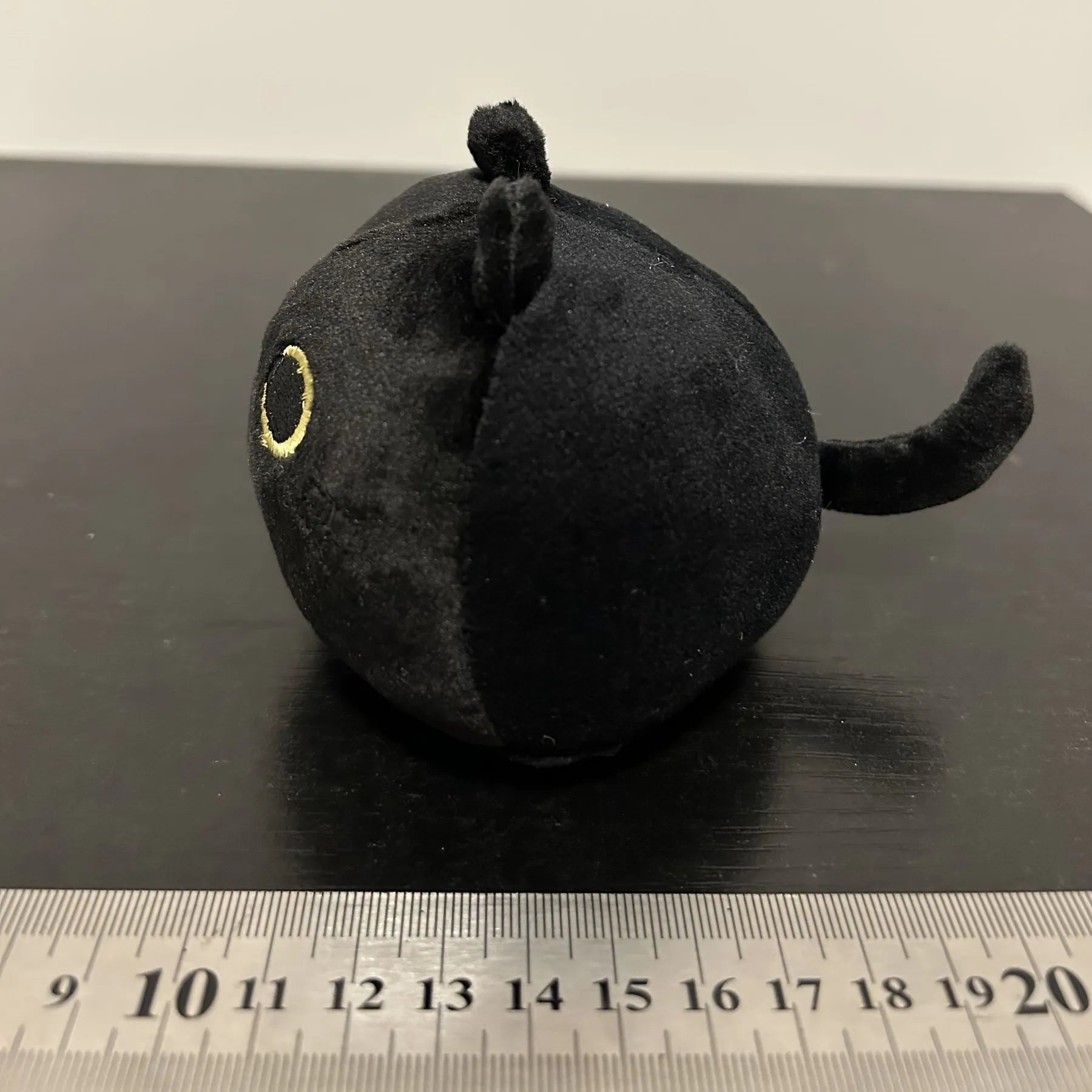 Fluffy black cartoon cat plush toy, 28cm tall, on a neutral background.