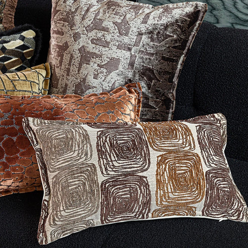 Abstract coil pattern pillow cover in cream and coffee colours on grey sofa