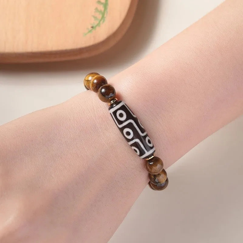 Single Tigereye Dzi bead Buddha rosary bracelet on wrist, showing simple ethnic design.