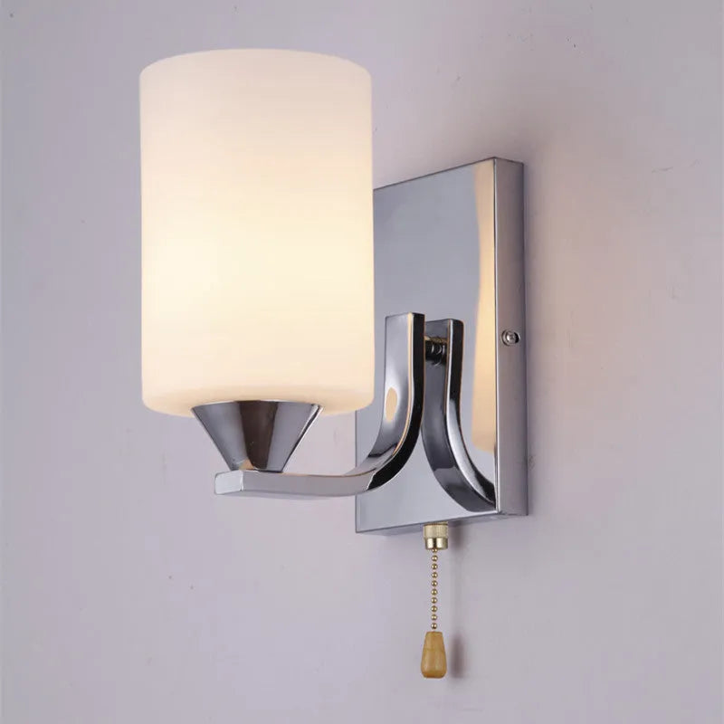 Minimalist chrome-finished glass wall lamp with single head configuration on white wall