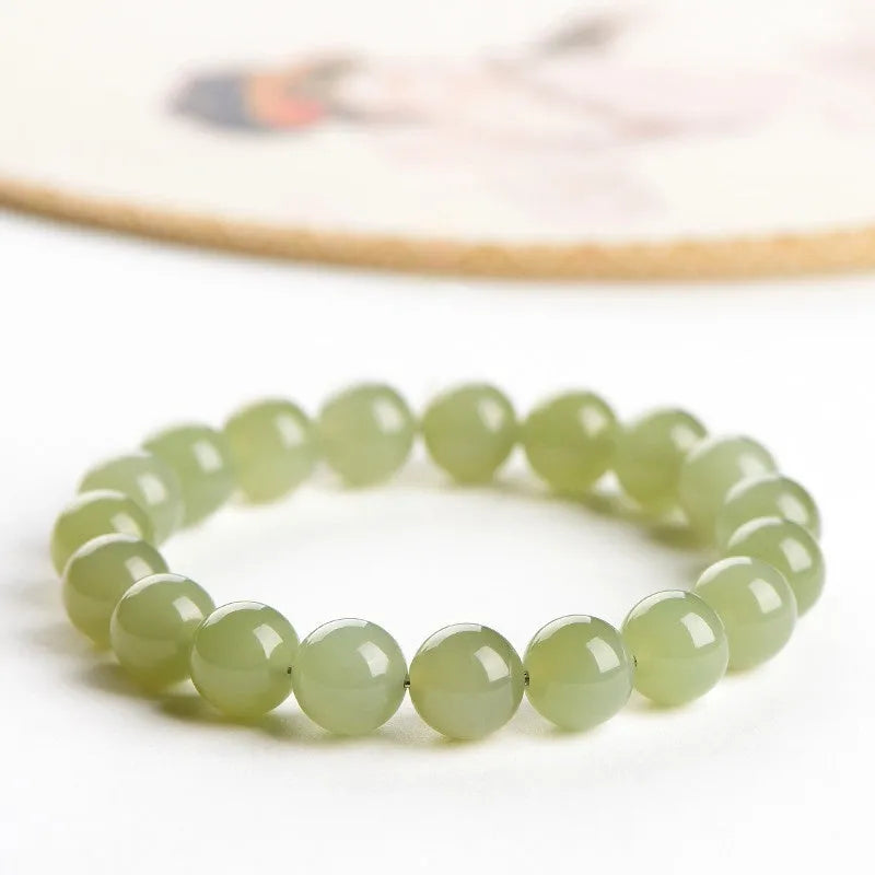 Polished Hetian jade bead bracelet in ice-like clear water colour on a wrist.