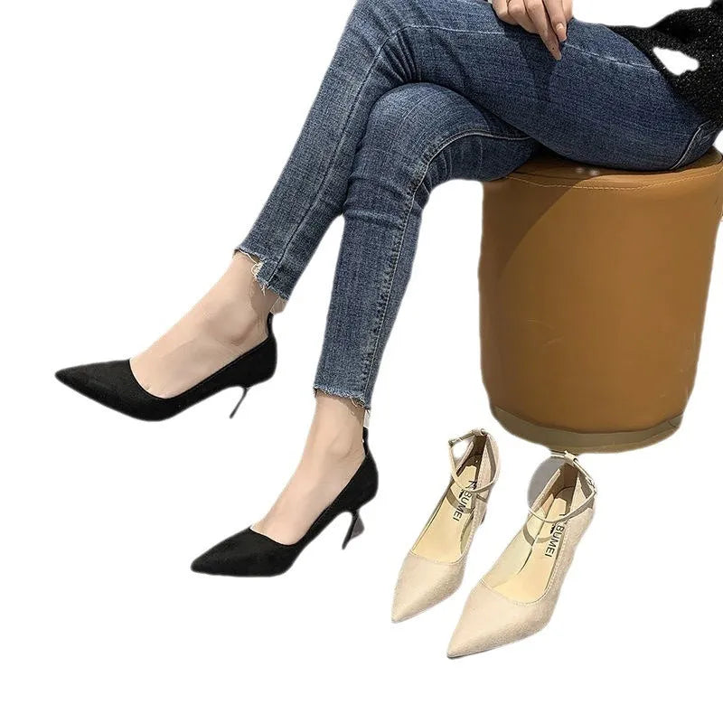 Women's black stiletto heel pump with ankle buckle detail and a rubber sole.