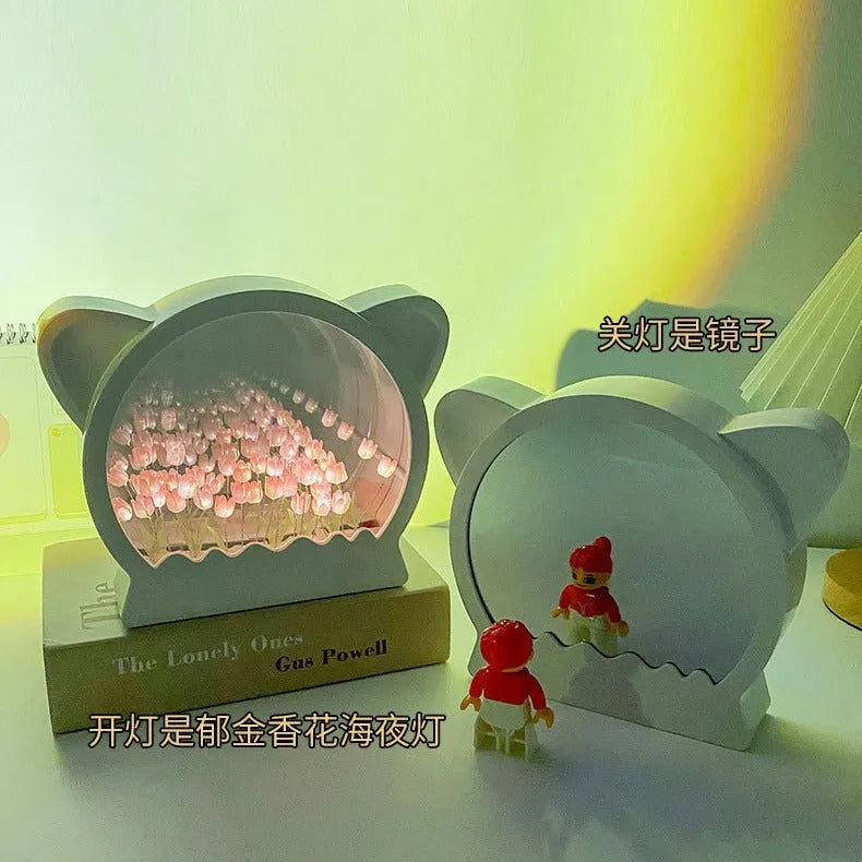 Handmade DIY cat head shaped night lamp surrounded by colourful tulip flowers on a table.