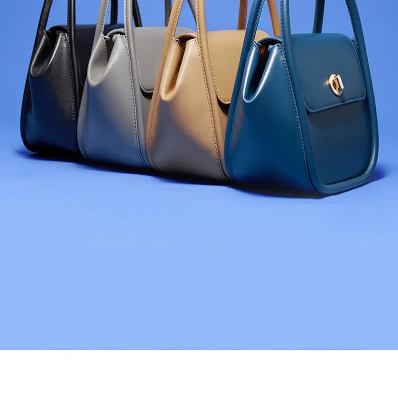 Women's leather wing-shaped tote bag with buckle closure in blue, grey, black, or brown colour options
