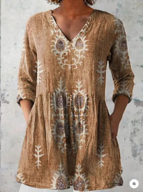 A woman wearing a loose-fitting printed dress with 3/4 sleeves and a wide waist.
