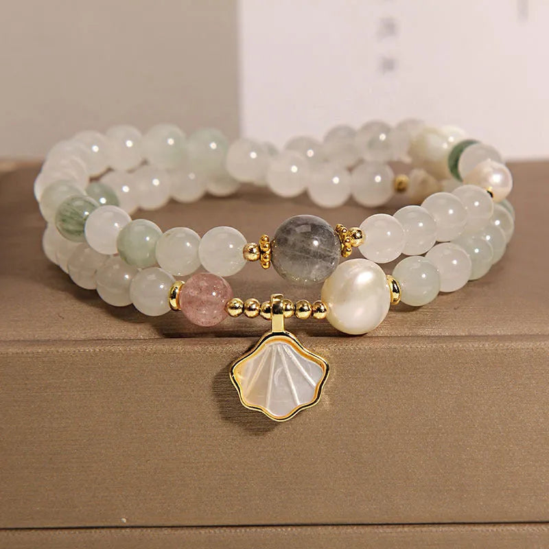 Women's artistic crystal bracelet with a green Tianshan Jade ginkgo leaf pendant and gold-plated accents.