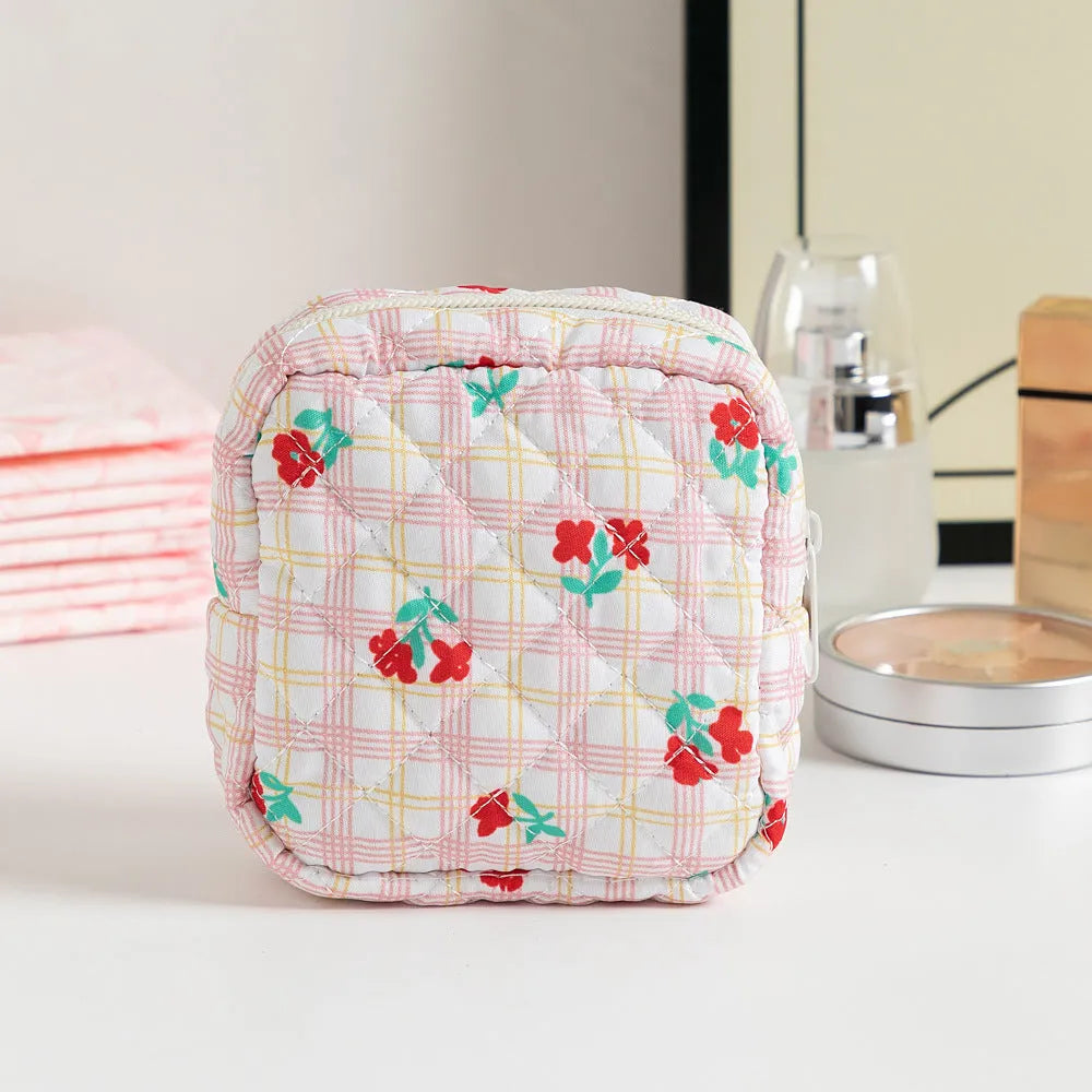 Yellow floral polyester key storage bag with sewing thread detail next to red small flower design variant.