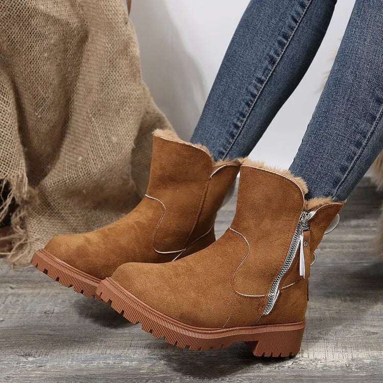 Women's black snow boots with foldable plush tube, suede upper, and rubber sole on winter pavement