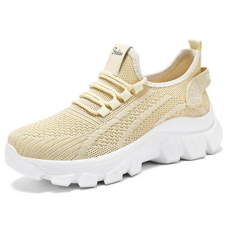 Women's white Flyknit running sneakers with round toe, flat heel, and thick PVC sole on a light background.