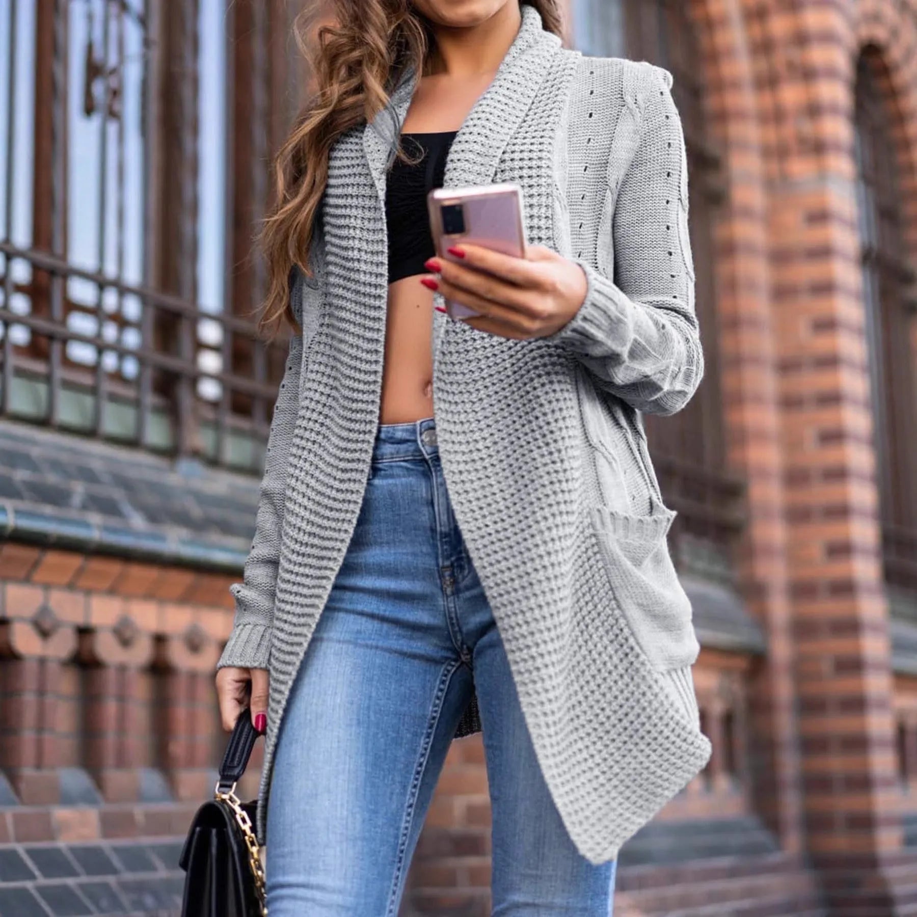 A grey women's loose-fit cardigan coat with pockets and long sleeves.