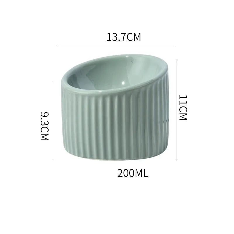 Elevated ceramic cat bowl in green, showing tilted design and raised height for feeding.