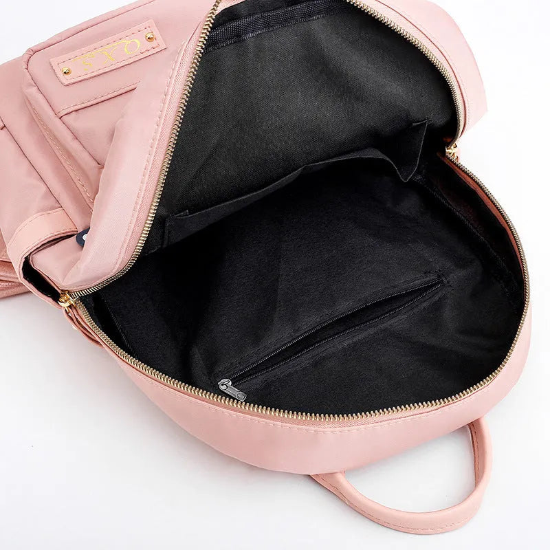 Women's casual nylon backpack in black or pink with square shape, showing external pocket and double straps.