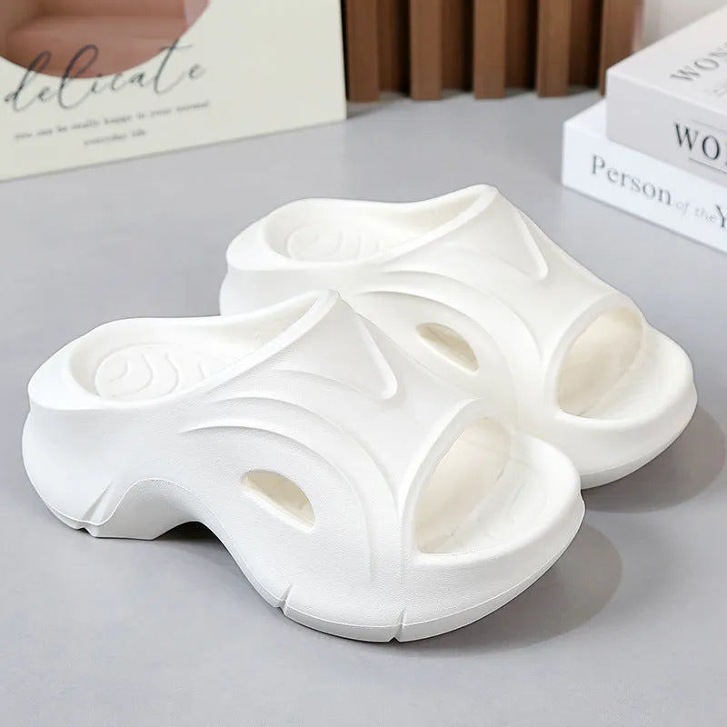Women's thick-soled EVA slippers in rose red colour on a sandy beach.