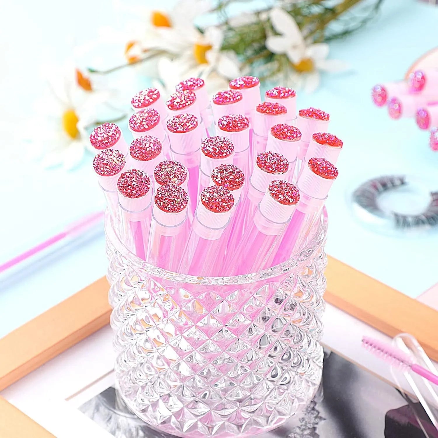 Disposable eyelash brushes in blue, green, pink and purple colours with transparent protective storage tubes