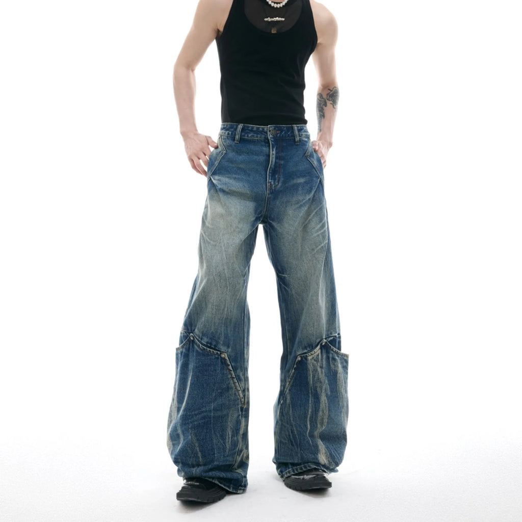 Man wearing verdant blue retro washed burst pattern loose fit jeans with a curved knife design.
