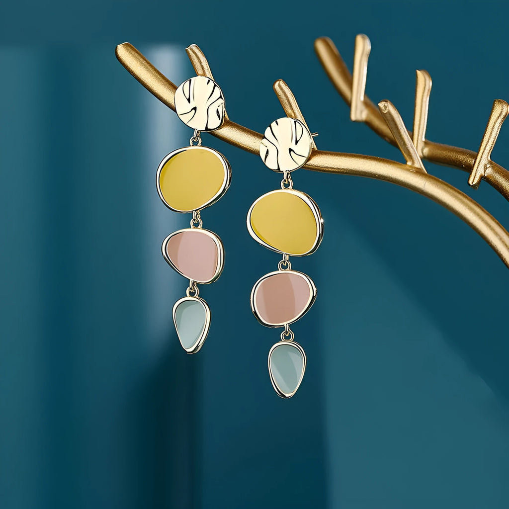 A pair of thin sterling silver stud earrings with Morandi-coloured wafer discs featuring an oil-drip texture.
