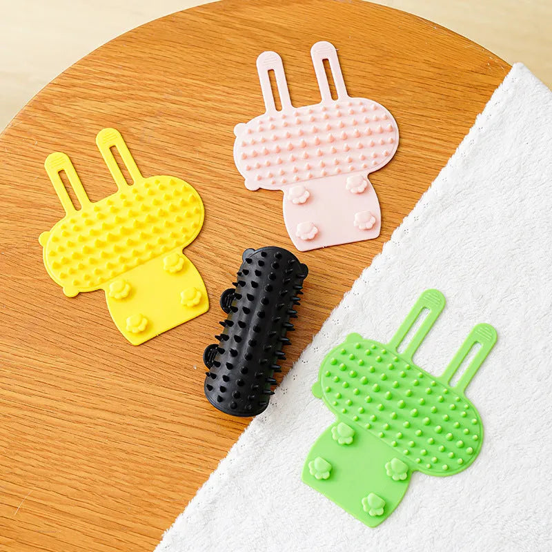 Silicone pet massage comb with adjustable strap attached to table leg