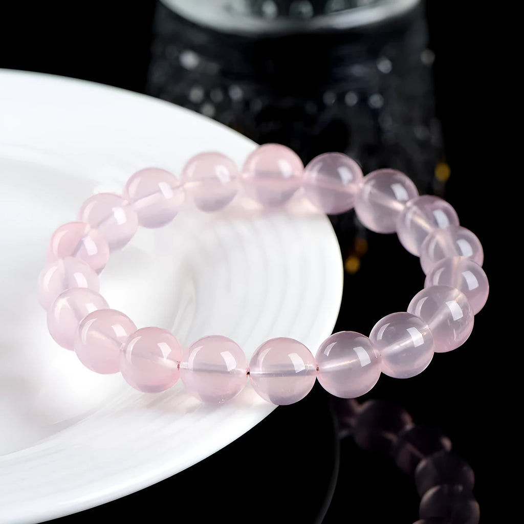 Pink crystal bracelet with round polished beads in natural starlight style showing size options from 6mm to 22mm diameter