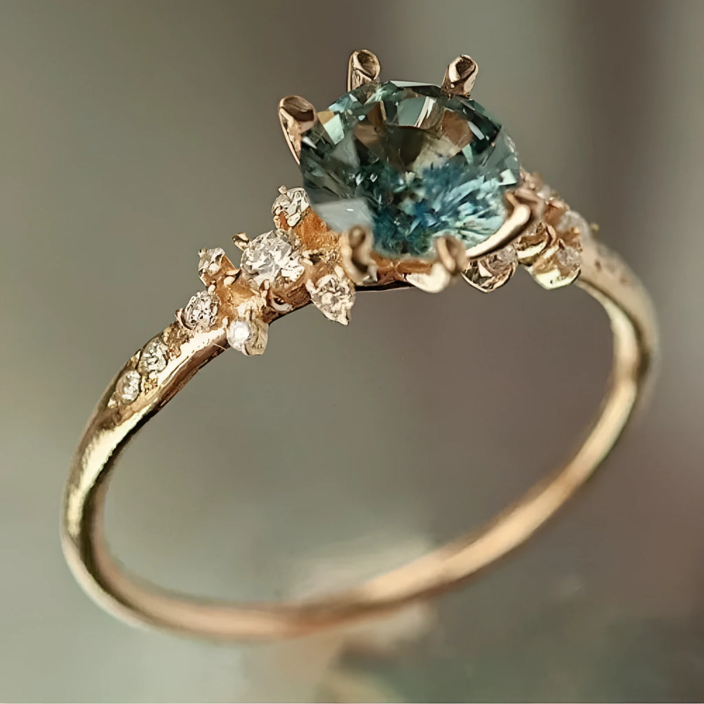 Gold plated geometric ring with claw inlaid zircon stones on a chamfered square pattern band.