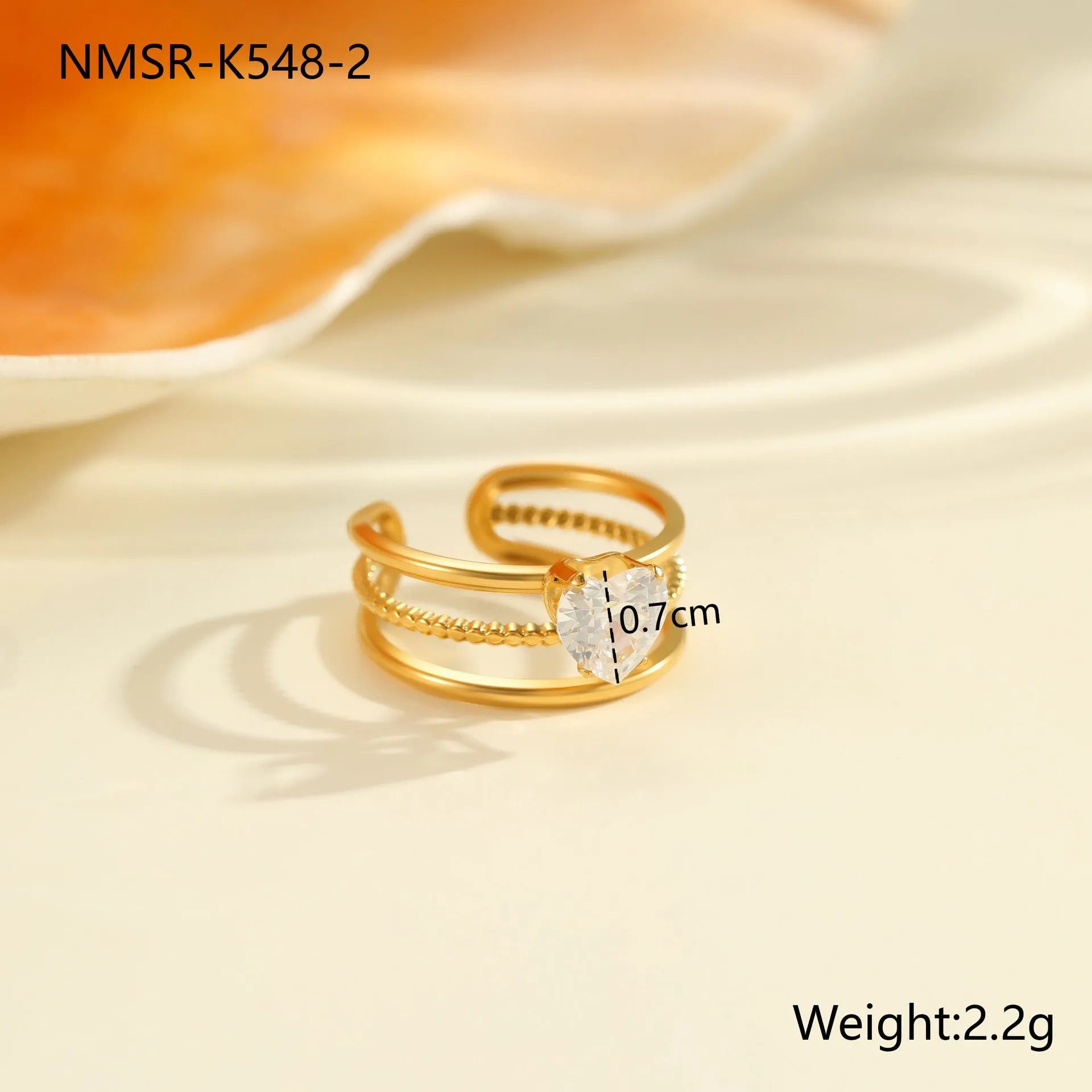 Gold-coloured adjustable stainless steel ring with zircon geometric shapes on white background.