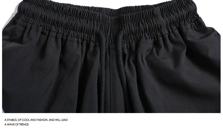 Black and grey loose-fit quick-drying sports shorts with elastic waistband above knee length