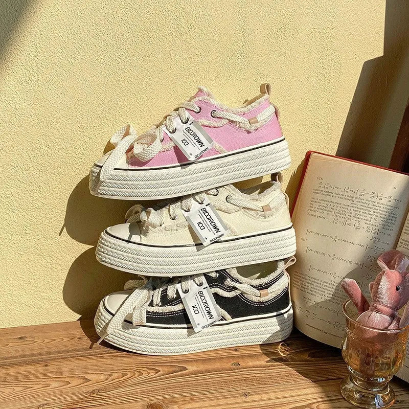 Women's low-top canvas shoes in solid colour with vulcanised rubber sole, available in beige, black, and pink.