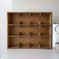 Square birch wood cup storage rack with multiple grid compartments for organising drinkware.