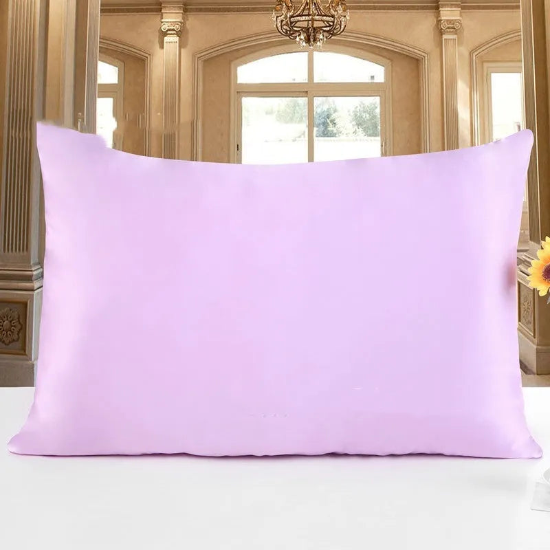 19 M double-sided silk pillowcase in apricot colour on a bed.