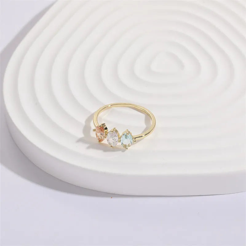 Geometric birthstone ring with horse eye shaped tricolor zircon stones in gold colour