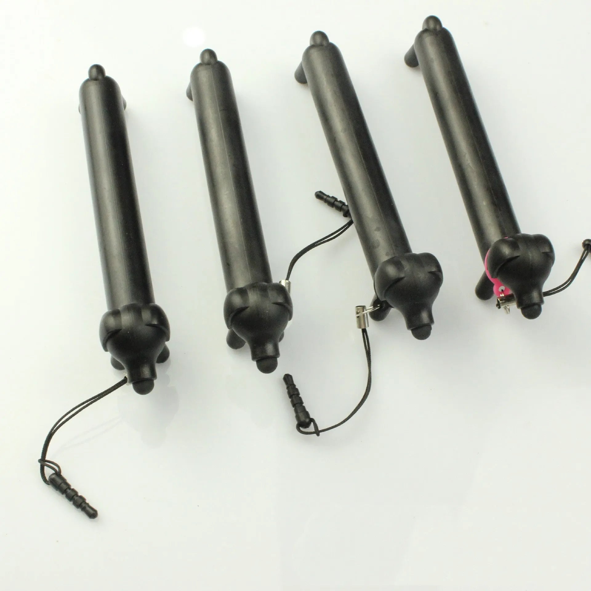 Black dog-shaped touch screen stylus showing length adjustment and phone holder function