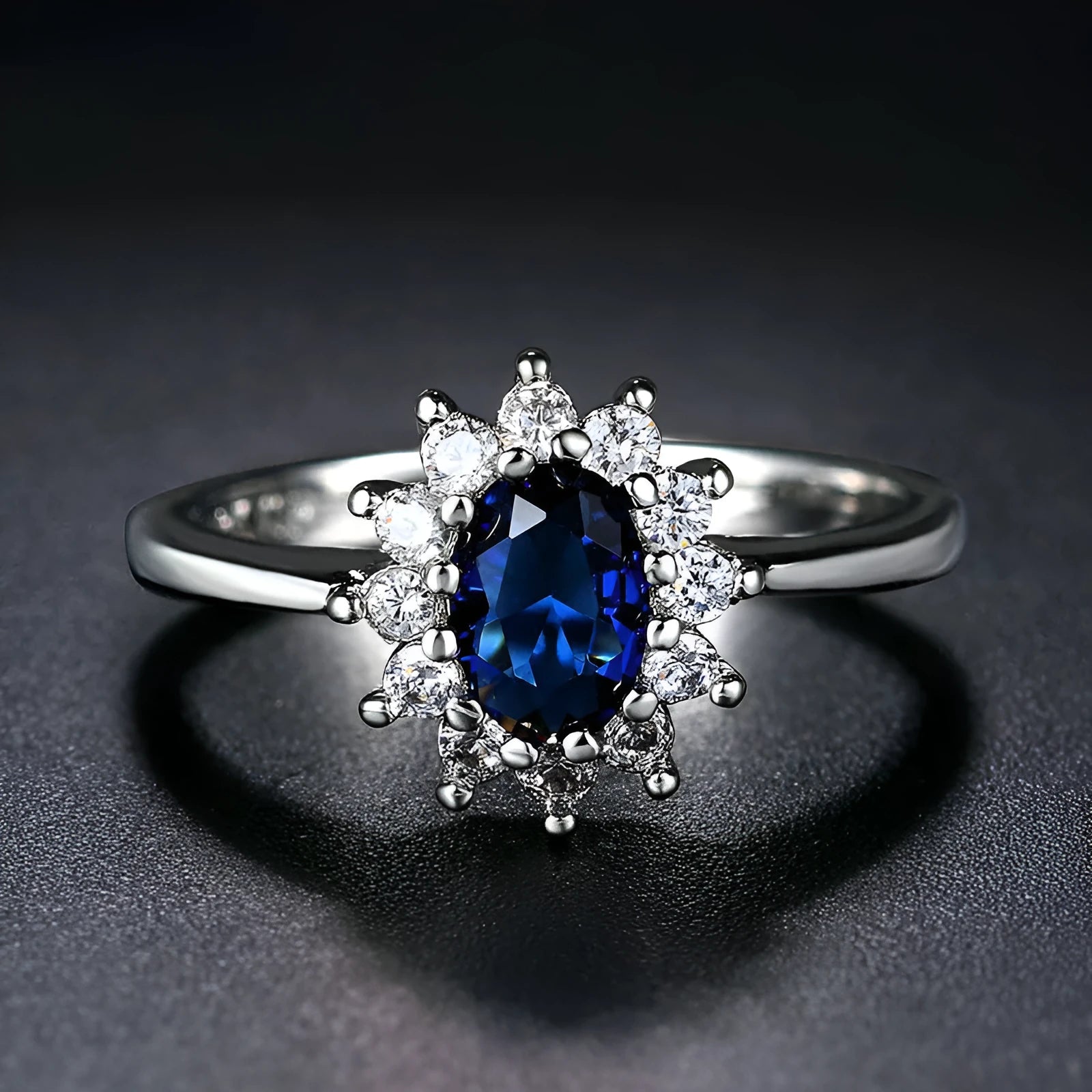 Copper women's ring with floral band and inlaid blue zirconium stone, shown on a finger.