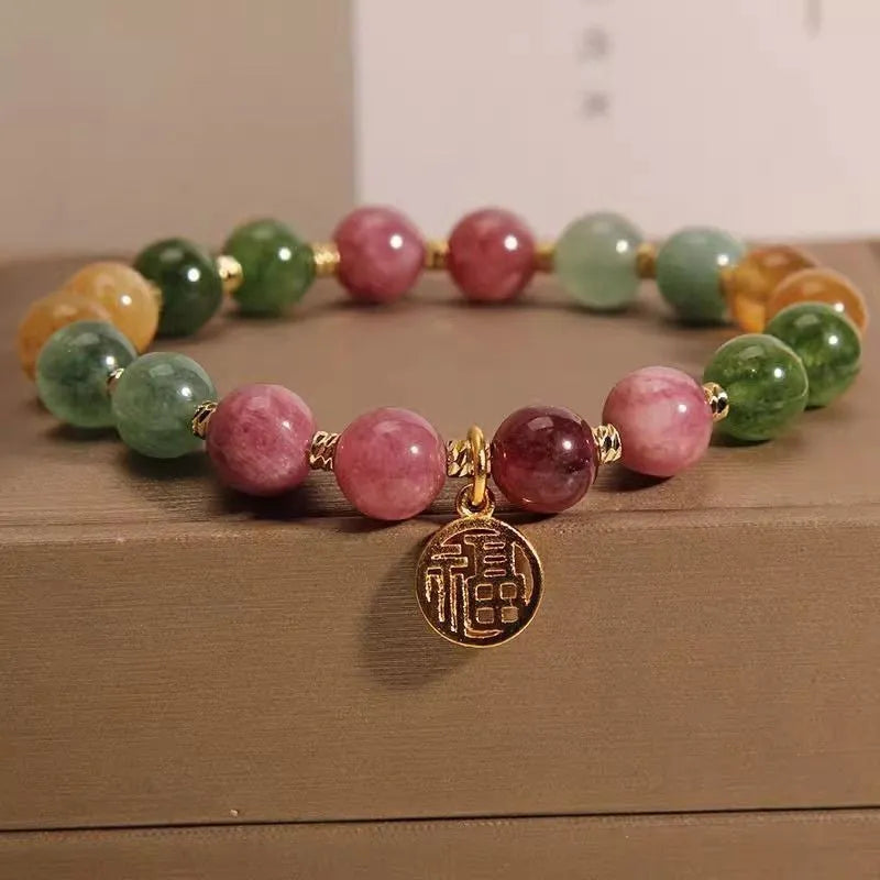 Natural colour tourmaline bracelet with floral and fu character charms on geometric electroplated chain