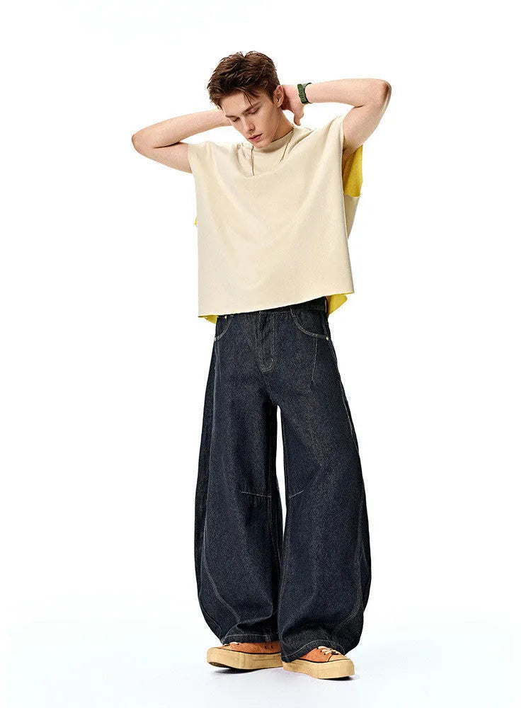 Men's original cow colour wide leg denim trousers laid flat showing mid-waist and relaxed leg cut
