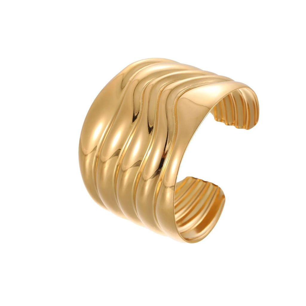Gold plated wide stainless steel bracelet with a geometric wave shape and a niche opening.