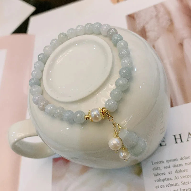 Emerald green jade bracelet with hand-carved gourd charm and pearl decoration in Chinese style