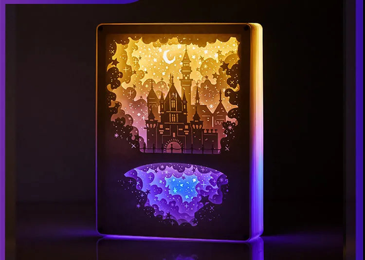 Modern romantic night light with three-dimensional paper carving design and remote control on a bedside table.