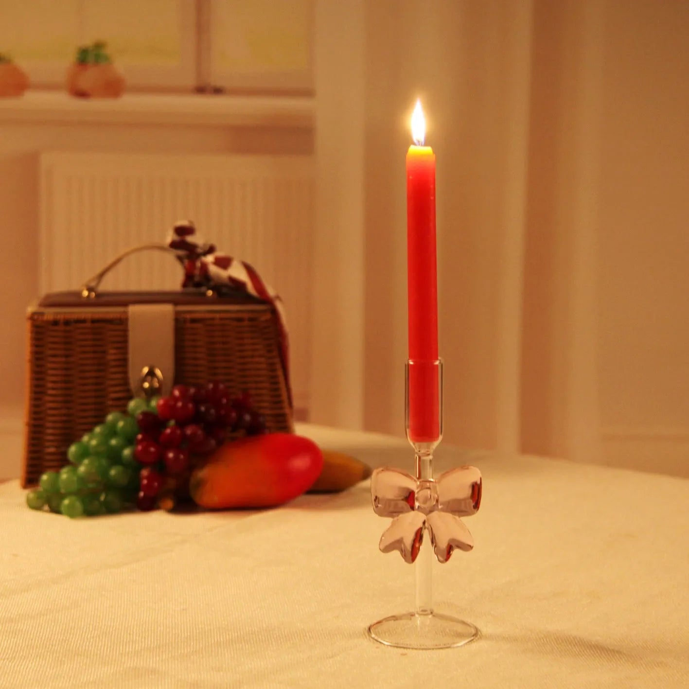 Set of three clear borosilicate glass candlesticks with large bow decorations on a table