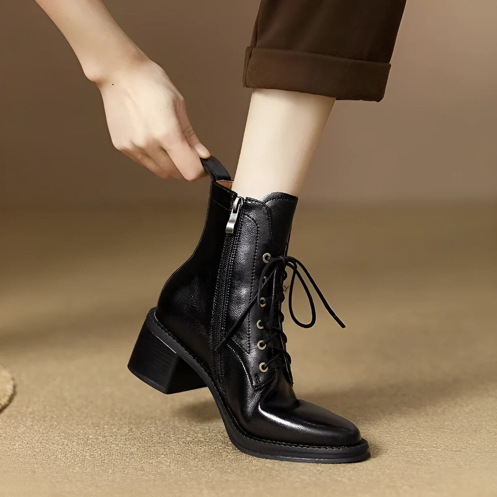 Women's black pointed-toe short tube boots with a 5.5cm heel on a plain background.