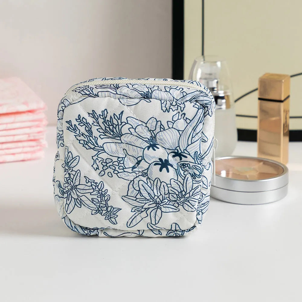 Yellow floral polyester key storage bag with sewing thread detail next to red small flower design variant.
