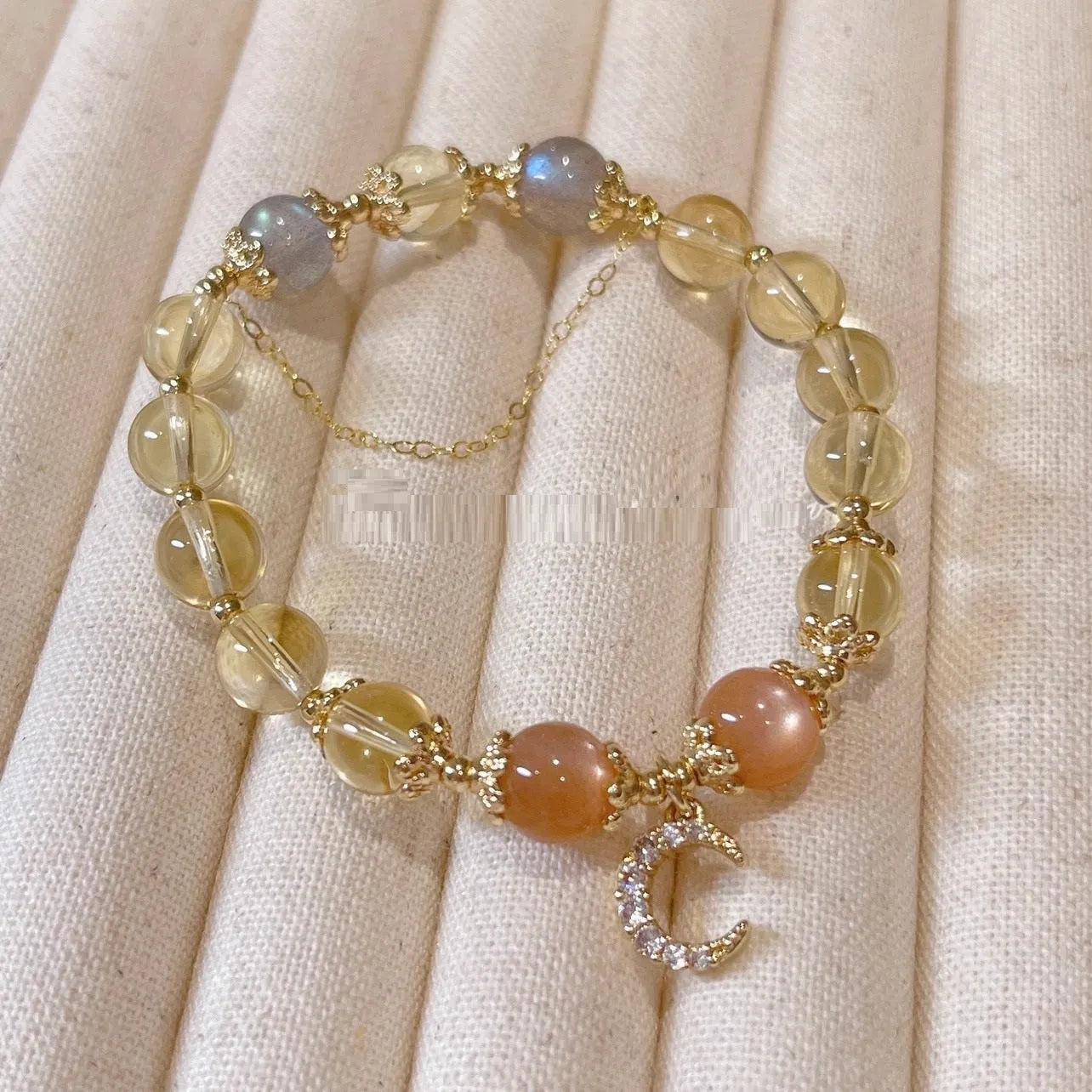 Women's crystal bracelet with moonstone and golden sun stone centrepiece, 14K gilded electroplated links, Chinese diamond-shaped style.