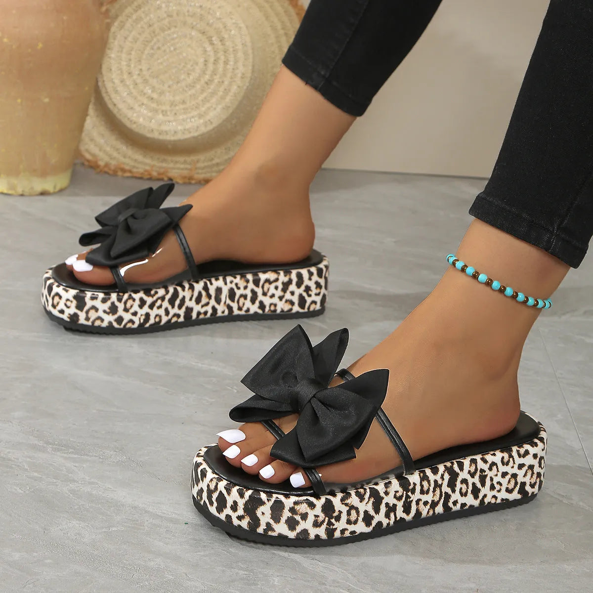 Women's black and white leopard print beach slippers with a thick platform sole.