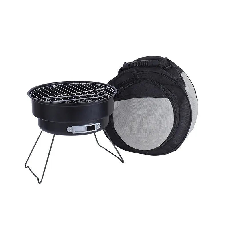 Small round metal camping stove with folding legs, mesh grill pan, charcoal clip, and carry bag.
