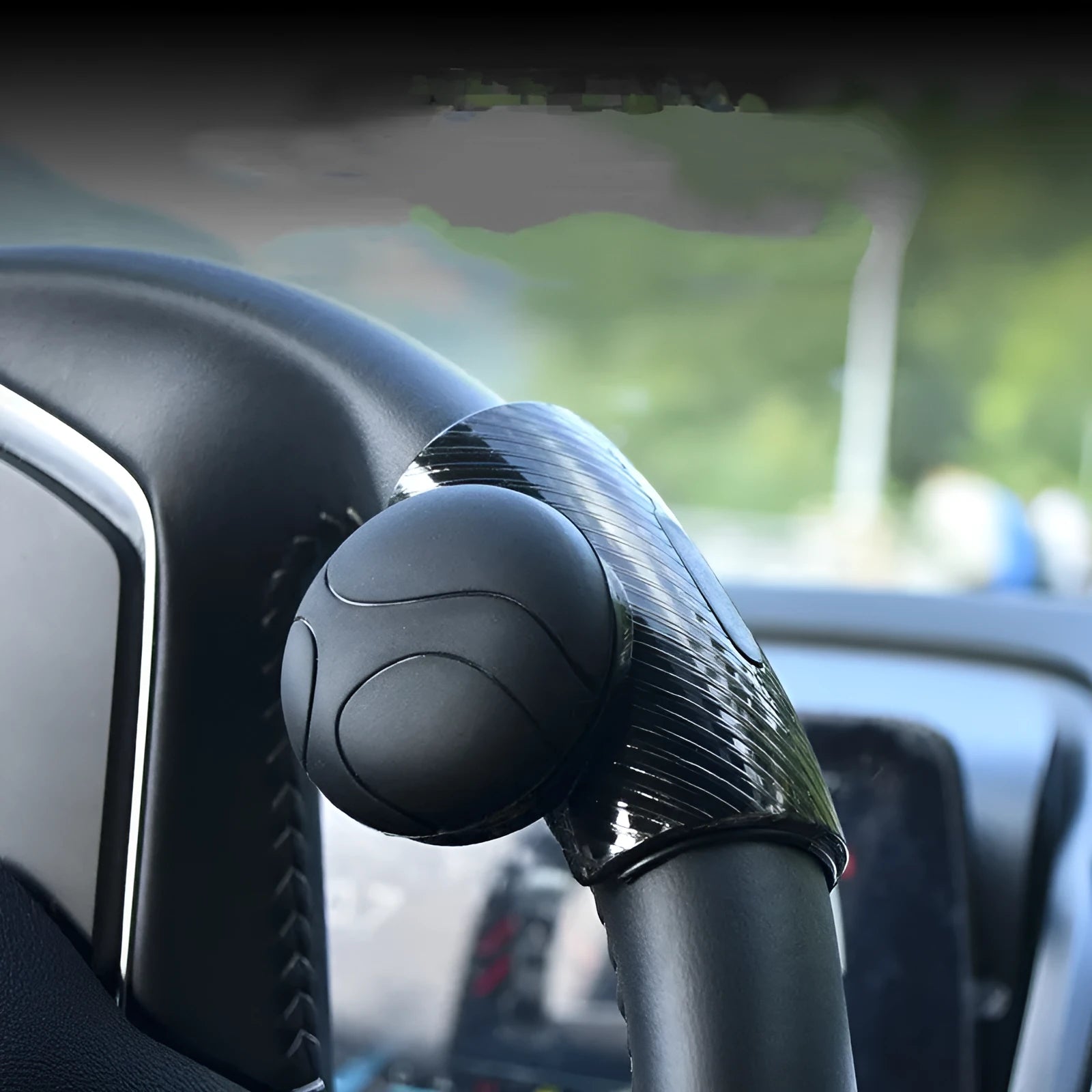 Black silicone steering wheel assist ball with metal bearing mounted on car steering wheel