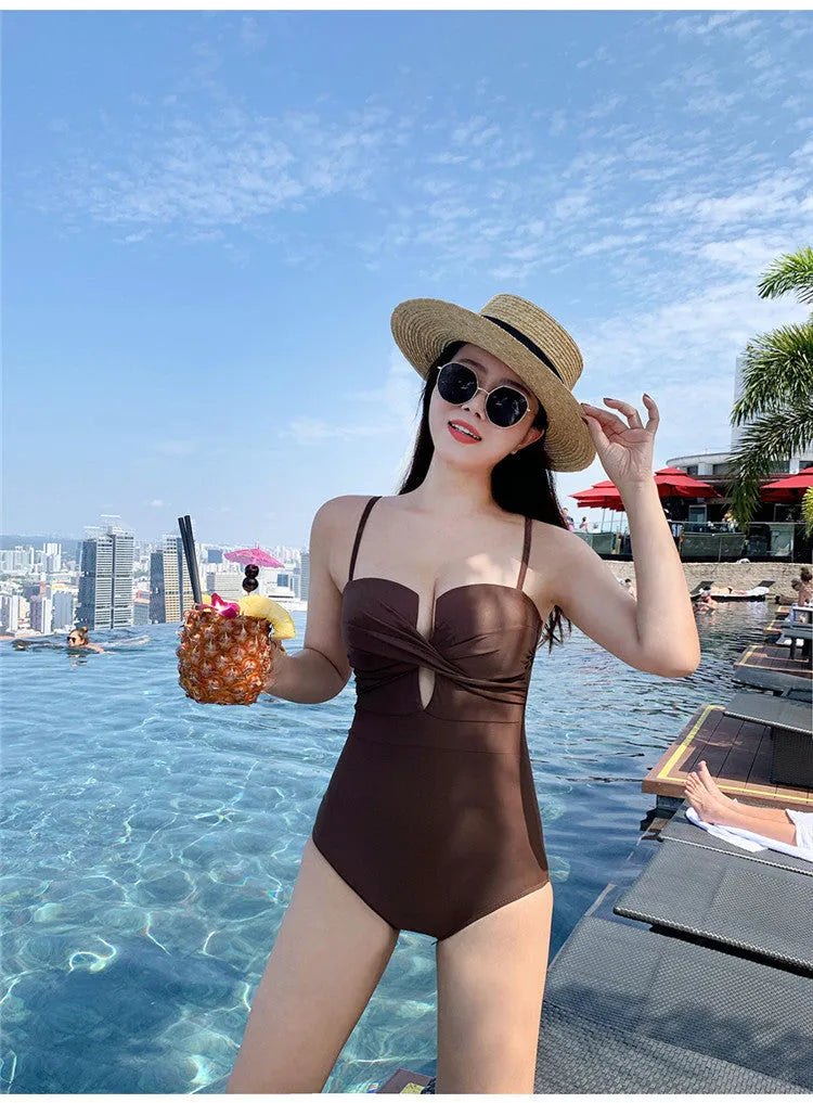 White one-piece swimsuit with spaghetti straps and push-up design on a mannequin.