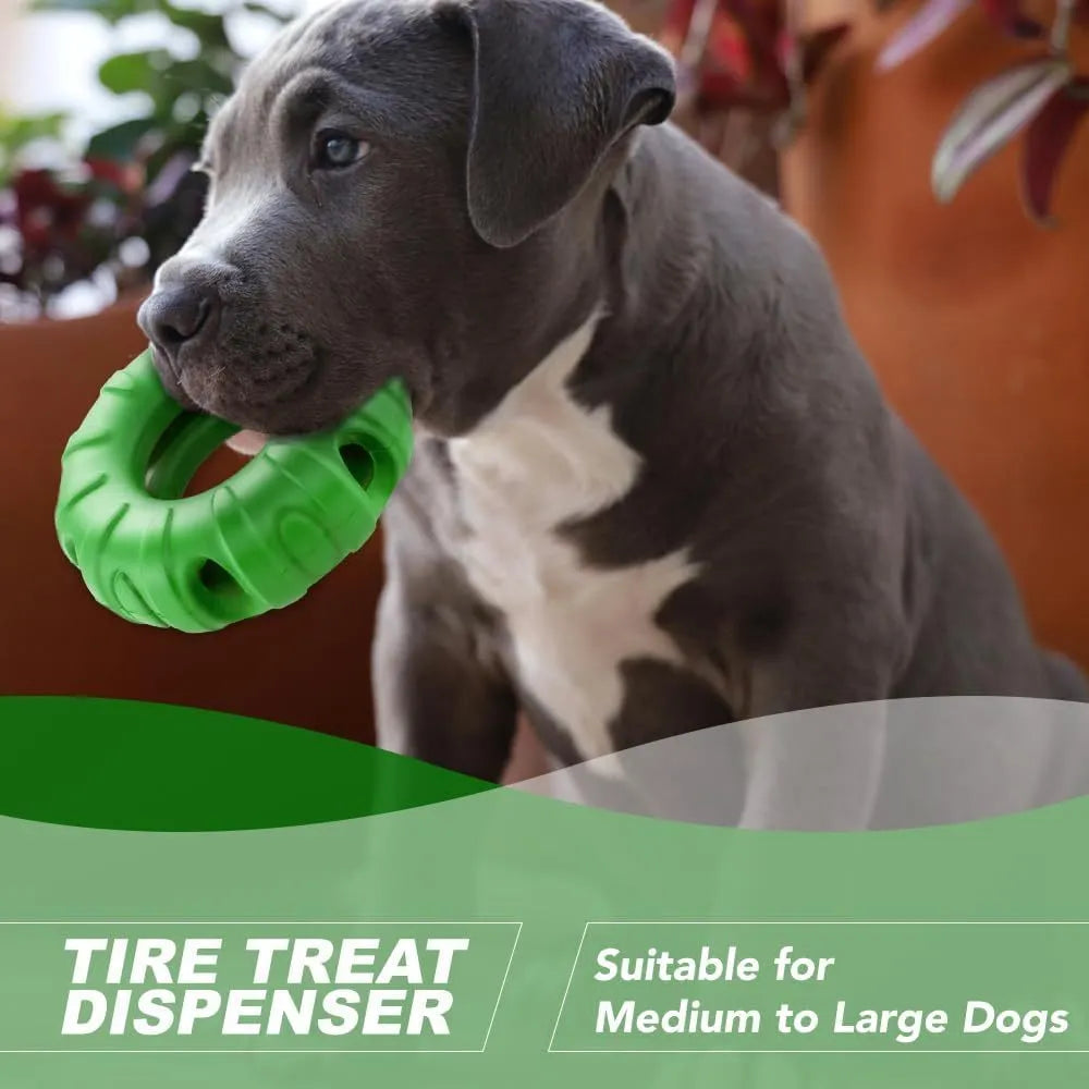 Blue tyre-shaped dog chew toy with oval openings for treat dispensing on a wooden floor.
