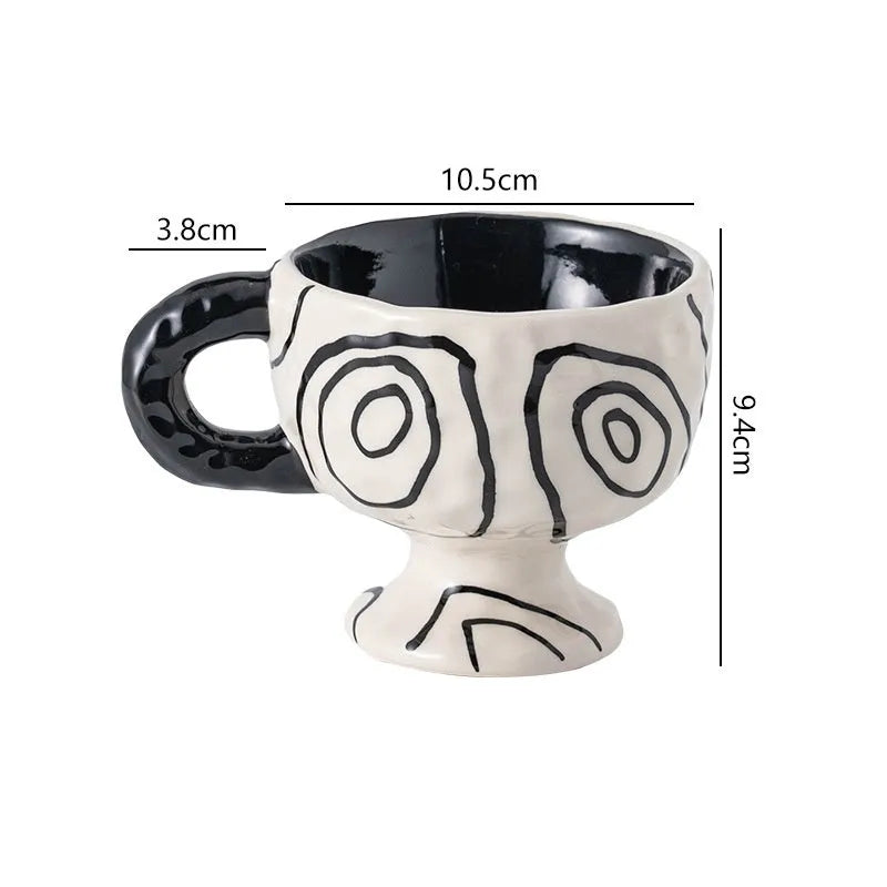 Hand-pinched irregularly shaped ceramic mug in a solid colour, shown on a table.