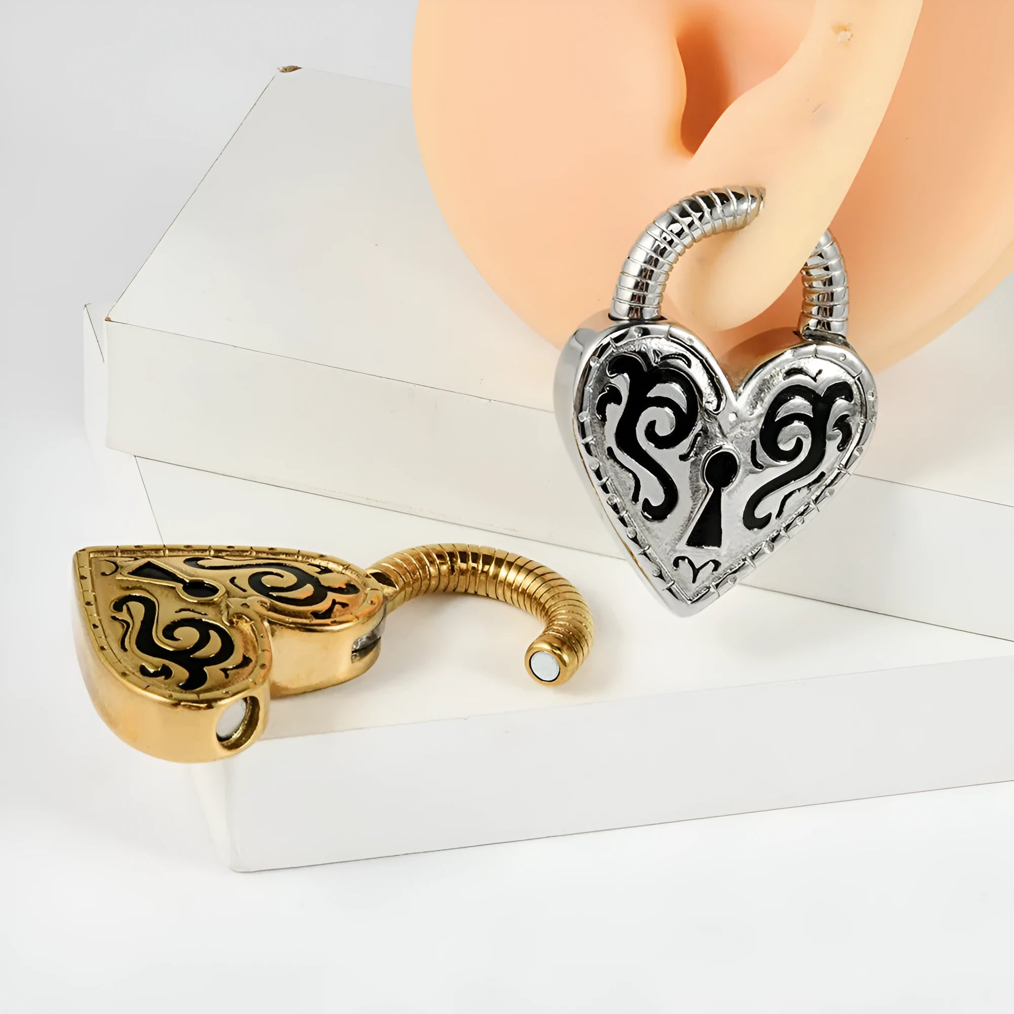 A pair of women's heart-shaped earrings in stainless steel with a gold electroplated finish.