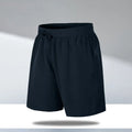 Man wearing loose-fit black quick-drying polyester beach shorts with a micro-elastic waistband.